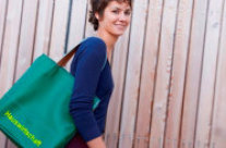 Junge Frau trägt Tasche mit Aufschrift 'Hauswirtschaft' unter dem Arm